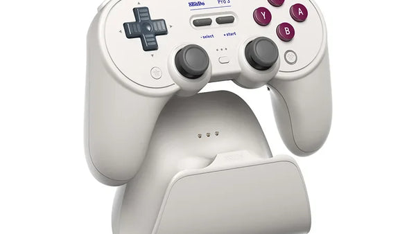 Light-colored 8BitDo Pro 3 with symmetrical lower sticks on its matching dock.